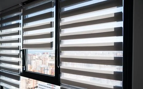 Zebra roller blinds partially open on modern apartment windows Stock Photos