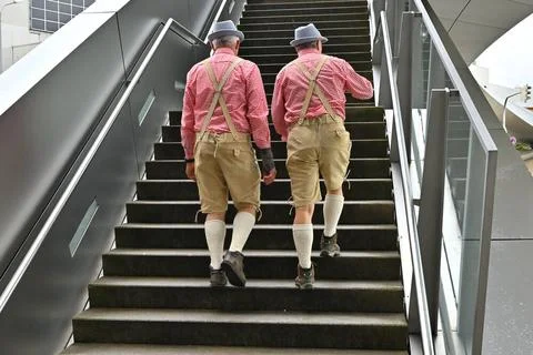 Zeitlose Tracht. Zwei Männer in Tracht gehen die Teppe nach oben. München . Stock Photos
