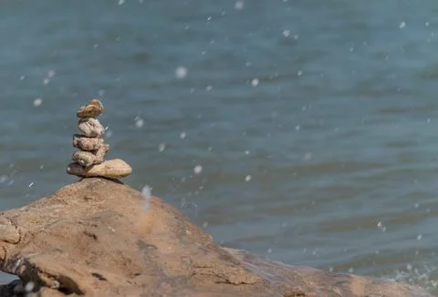 Zen concept. Object made of stone on the beach. Stone pyramid for meditation. Stock Photos
