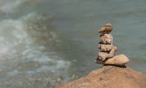 Zen concept. Object made of stone on the beach. Stone pyramid for meditation. Stock Photos