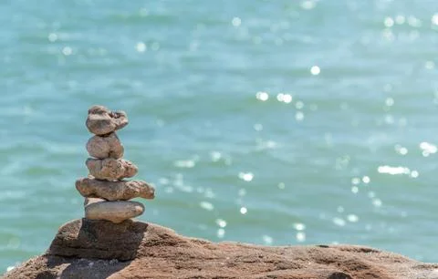 Zen concept. Object made of stone on the beach. Stone pyramid for meditation. Stock Photos