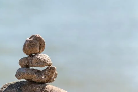 Zen concept. Object made of stone on the beach. Stone pyramid for meditation. Stock Photos
