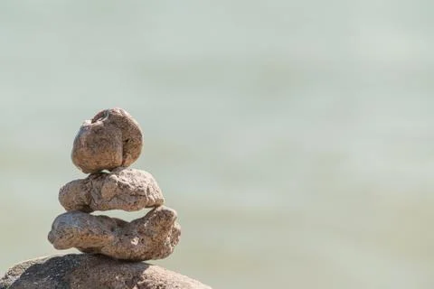 Zen concept. Object made of stone on the beach. Stone pyramid for meditation. Stock Photos