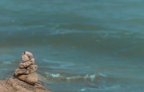 Zen concept. Object made of stone on the beach. Stone pyramid for meditation. Stock Photos