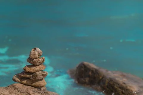 Zen concept. Object made of stone on the beach. Stone pyramid for meditation. Stock Photos