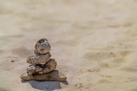 Zen concept. Object made of stone on the beach. Stone pyramid for meditation. Stock Photos