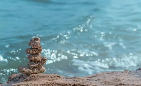 Zen concept. Object made of stone on the beach. Stone pyramid for meditation. Stock Photos