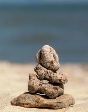 Zen concept. Object made of stone on the beach. Stone pyramid for meditation. Stock Photos