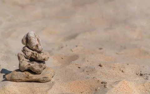 Zen concept. Object made of stone on the beach. Stone pyramid for meditation. Stock Photos