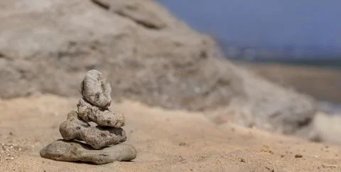 Zen concept. Object made of stone on the beach. Stone pyramid for meditation. Stock Photos