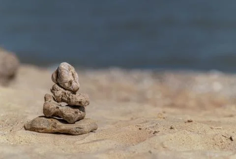 Zen concept. Object made of stone on the beach. Stone pyramid for meditation. Stock Photos