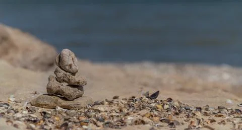 Zen concept. Object made of stone on the beach. Stone pyramid for meditation. Stock Photos