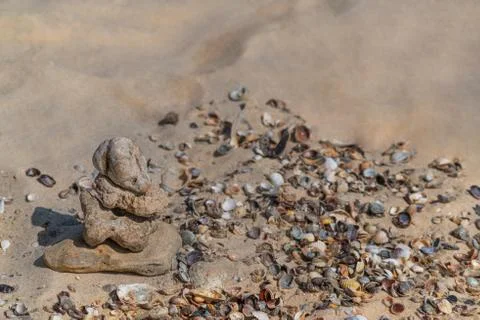 Zen concept. Object made of stone on the beach. Stone pyramid for meditation. Stock Photos