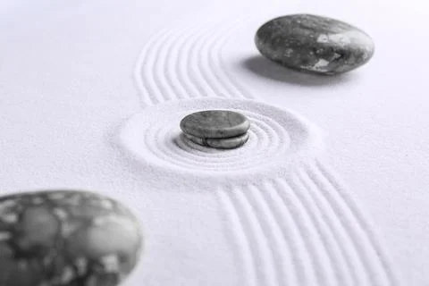 Zen concept. Stones and pattern on white sand, closeup Stock Photos