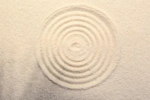 Zen rock garden. Circle pattern on beige sand, top view Stock Photos