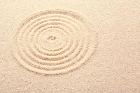 Zen rock garden. Circle pattern on beige sand Stock Photos