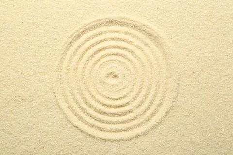 Zen rock garden. Circle pattern on beige sand, top view Stock Photos