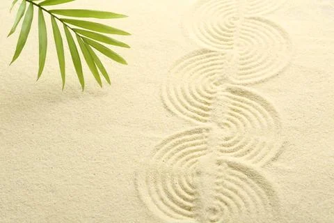Zen rock garden. Wave pattern and green leaf on beige sand 스톡 사진