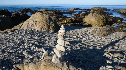 Zen rocks balanced stack on rocky Pacific Ocean shore with snowy egret bird Stock Footage 169043608
