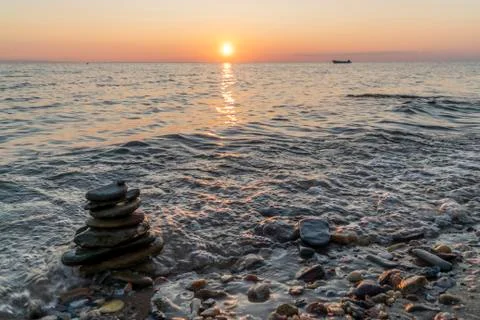 Zen stack of rocks in the sea at sunset 写真素材