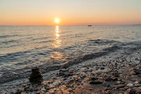 Zen stack of rocks in the sea at sunset Stock Photos