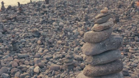 Zen stone stack balancing on pebble beach at sunset cinematic slow motion f.. Stock Footage 337719351