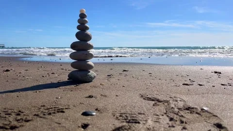 Zen stone tower on sandy beach with ocean wave background Stock Footage 310244974