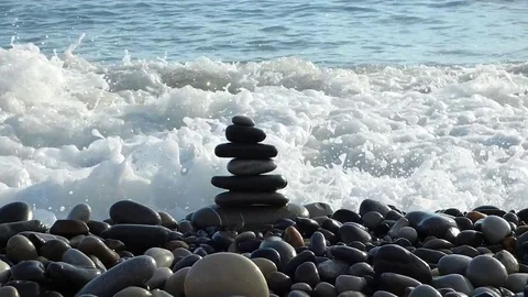 Zen stones stack on the beach breaking by sea surf Stock Footage 77433368