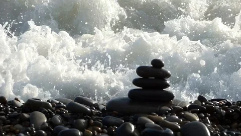 Zen stones stack on the beach breaking by sea surf Stock Footage 87990892