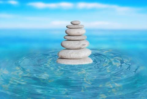 Zen stones stack from large to small in water with circular waves and blured Stock Photos
