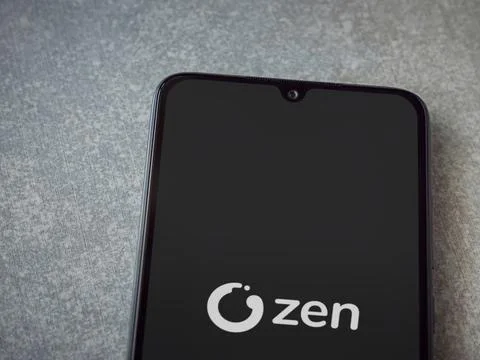 ZEN.COM app launch screen on smartphone on ceramic stone background Stock Photos