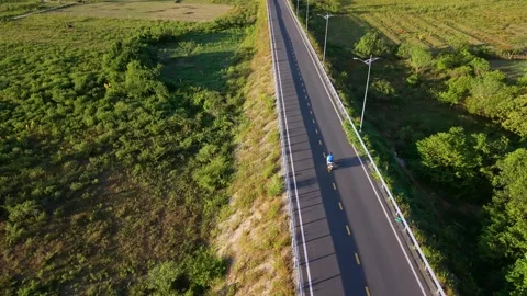 Zenith drone perspective of motorcycle crossing isolated bridge Stock Footage 336610338