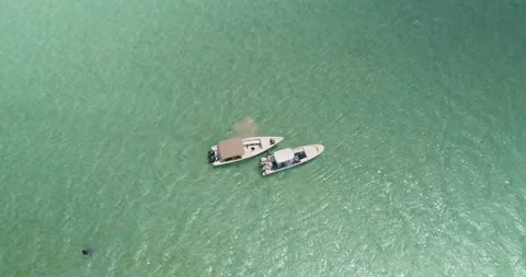 Zenith view two boats MOORED in flat turquoise sea water WAIT MEN Vidéo 221811898