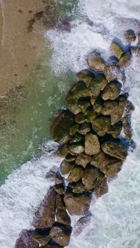 Zenith view of waves crashing on rocks near to  shore on a sunny day. Stock Footage 242747696