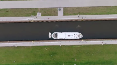 Zenithal zoom in over barge navigating tree-lined canal near Doerpen Lock Stock Footage 311903650