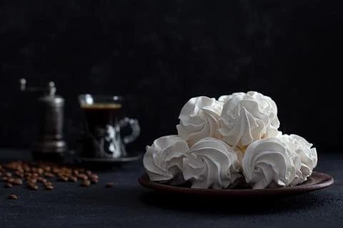 Zephyr on a dark background in a plate in the background - a cup of coffee. Stock Photos