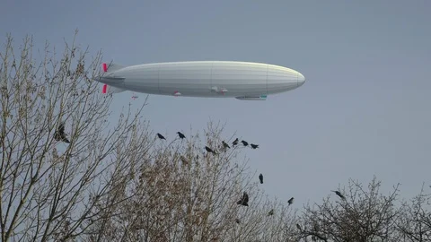 Zeppelin airship in background, flock of black ravens on trees in foreground Stock Footage 111983607