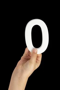 Zero in hand. The number zero is clasped in a hand isolated on a black Stock Photos
