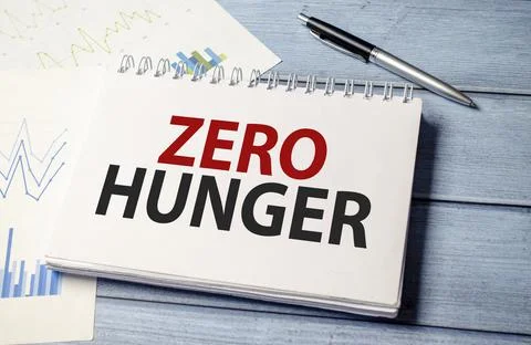 Zero hunger words on notepad, charts and blue wooden background Stock Photos