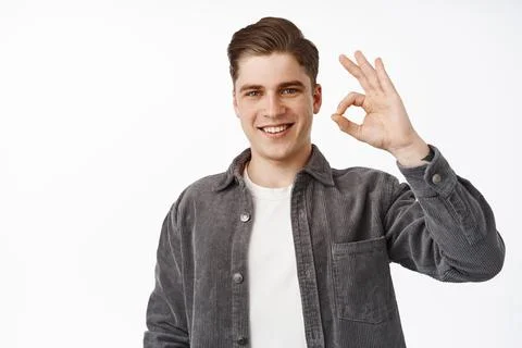 Zero no problems. Smiling young man shows okay OK sign, looks confident, assured Fotos Stock