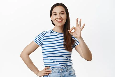 Zero problems. Smiling satisfied girl, 20s woman showing okay, OK sign and nod Фото