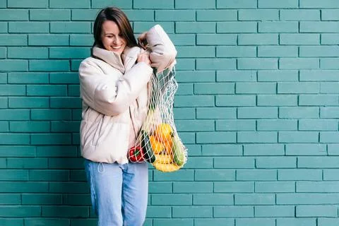Zero waste concept with copy space. Woman holding straw basket and reusable mesh Stock Photos