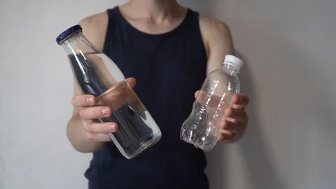 Zero waste concept. Man chooses a glass bottle instead of a plastic bottle. 動画素材 112817252