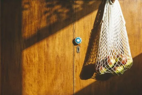Zero Waste concept. A string bag with apples and vegetables. White cotton Stock Photos