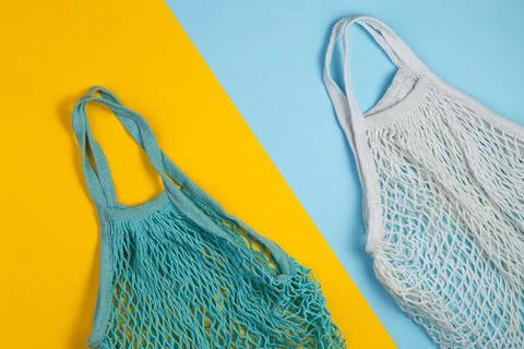 Zero waste concept. Two mesh shopping bags lie on yellow blue background Stock Photos