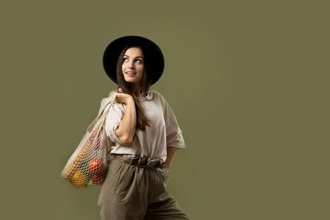 Zero waste concept. Young brunet woman holding reusable cotton shopping mesh bag Stock Photos