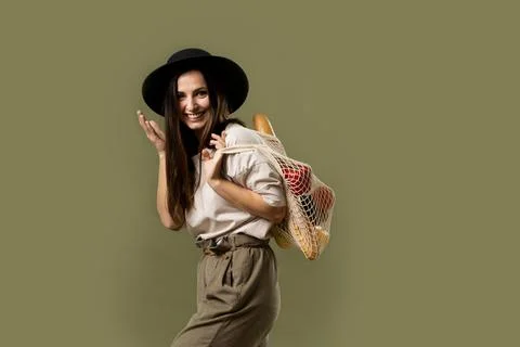 Zero waste concept. Young brunette woman in beige t-shirt and black hat holding Stock Photos