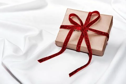 Zero waste Gift box with red velvet ribbon on white silk sheet. Romantic Stock Photos