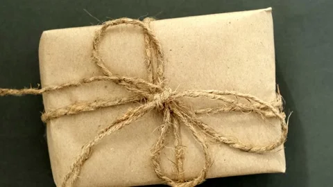 Zero waste gift in craft paper spins on black background. Black Friday Stock Footage 218597130