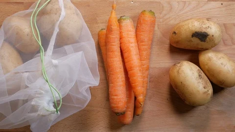 Zero waste lifestyle concept. Pull on carrots of the reusable bag Stock Footage 107221071